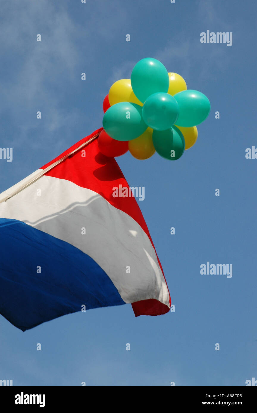 Nationalflagge von Holland an einem Mast mit Luftballons fliegen Stockfoto