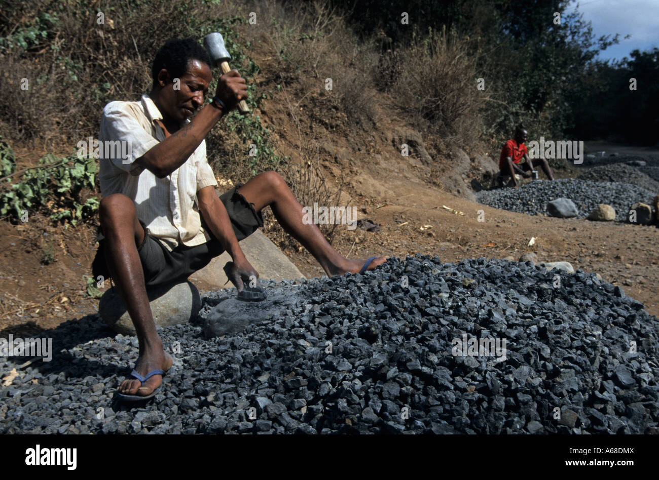Zerkleinerung von Steinen mit einem Hammer Mann; Moshi, Kilimanjaro-Region; Tansania Stockfoto