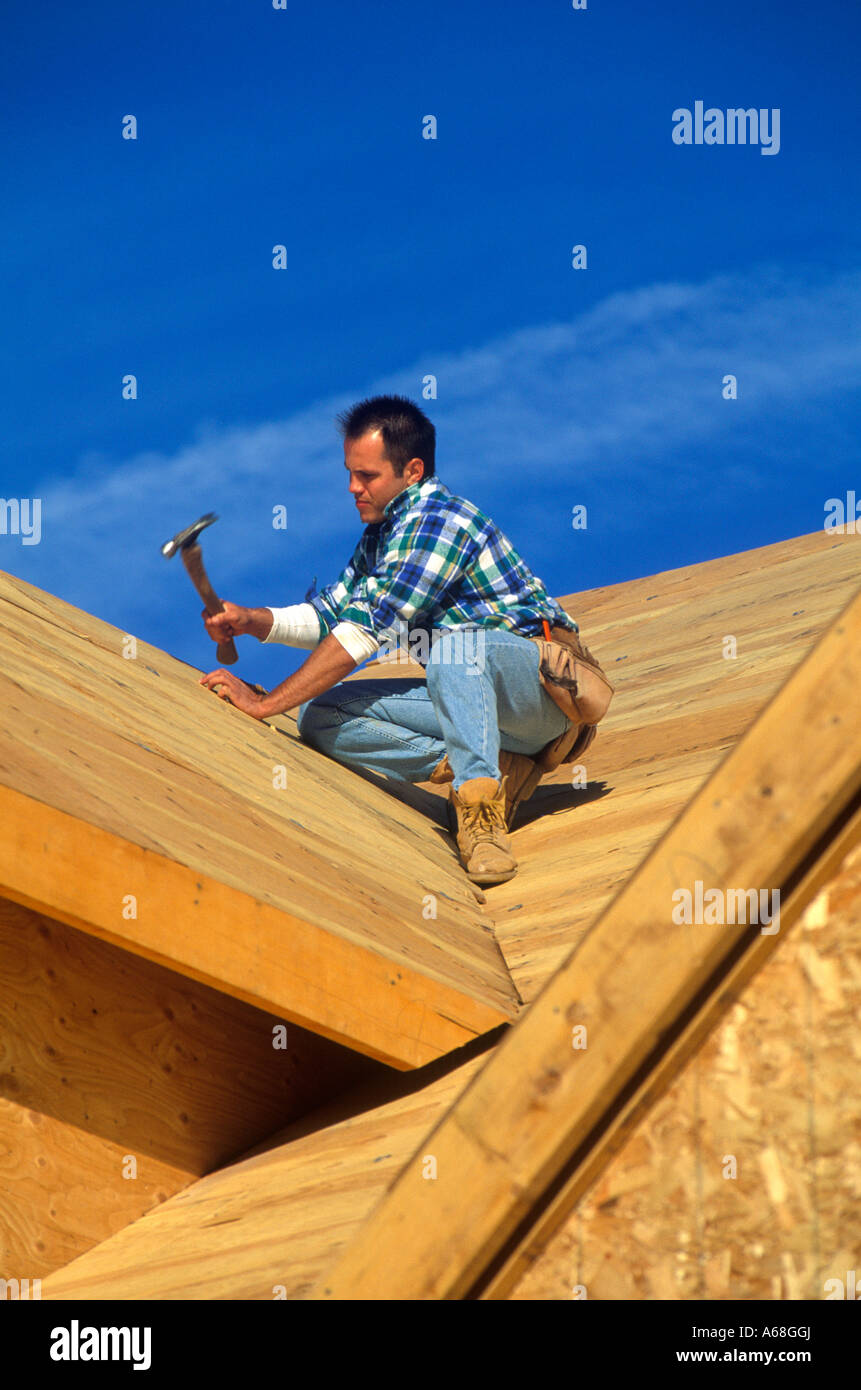 Bauarbeiter Hämmern auf dem Dach eine neue Haus-Herr Stockfoto