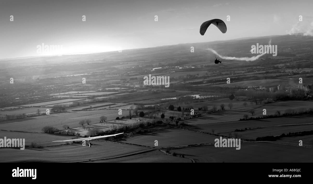 Drachenflieger und Paraglider über Landschaft, Wiltshire, UK. Rauch ist aus lokalen Zement Werke Schornstein. Stockfoto