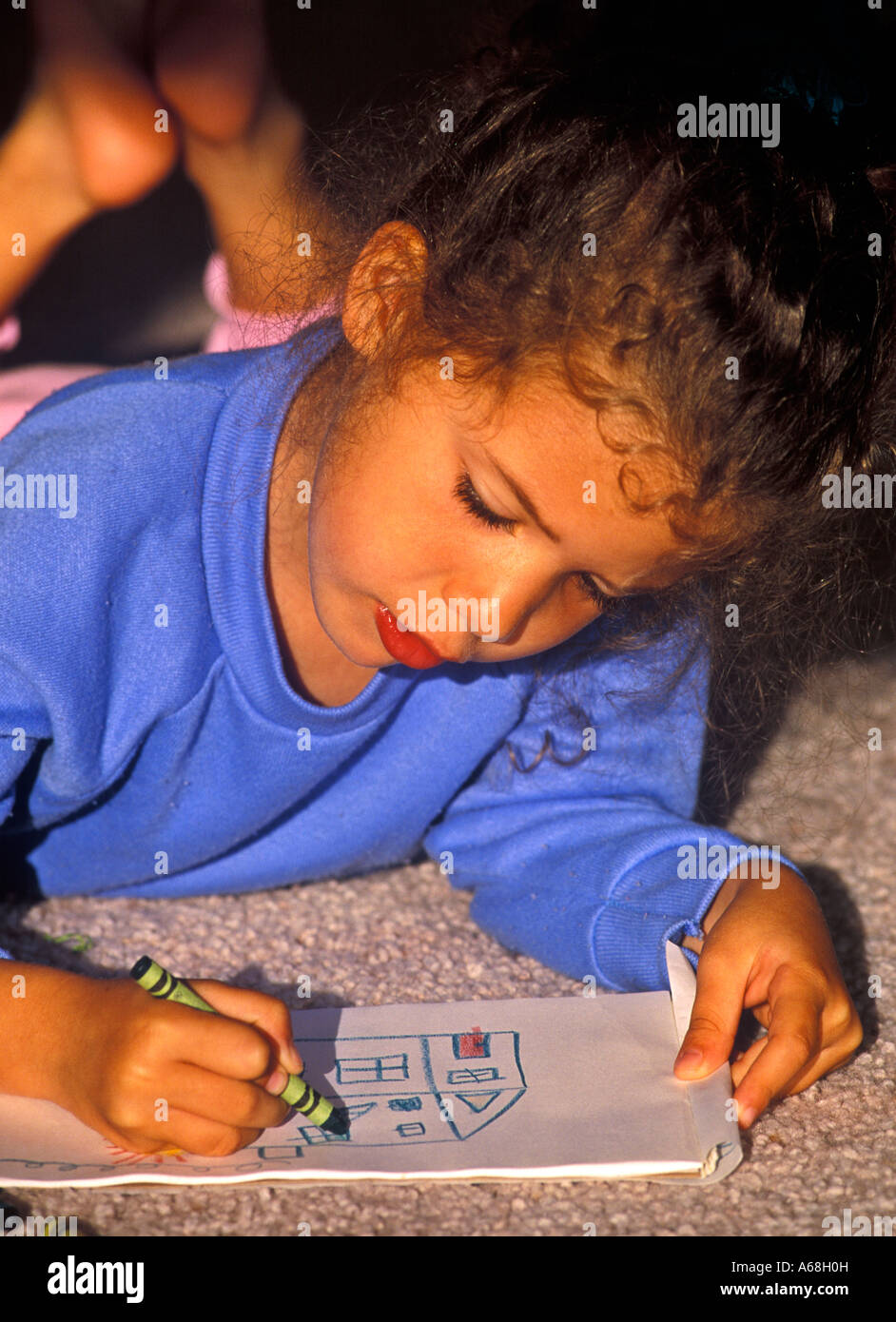 Pre-Schooler zeichnen ein Bild mit Buntstiften Stockfoto
