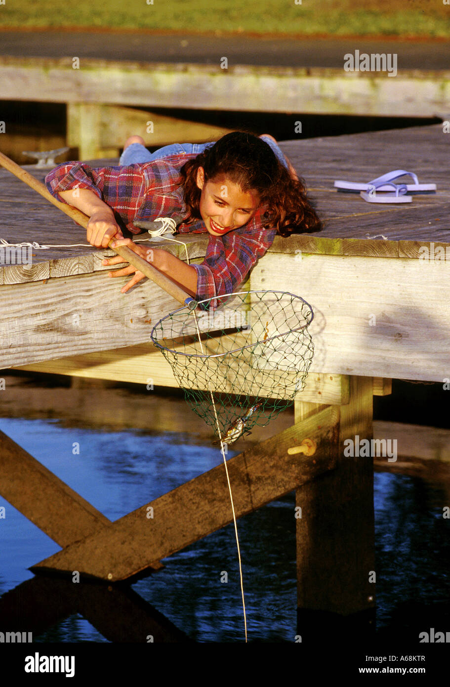 Junges Mädchen Krabben aus dem dock Stockfoto