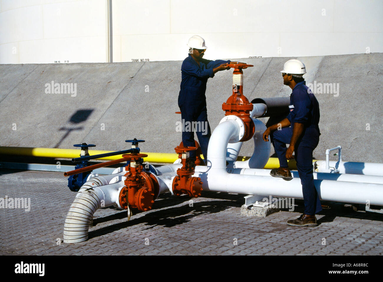 Terminal-Ölleitungen Dubai VAE Stop Ventil Gastarbeiter Männer In harte Hüte Lagertank Stockfoto