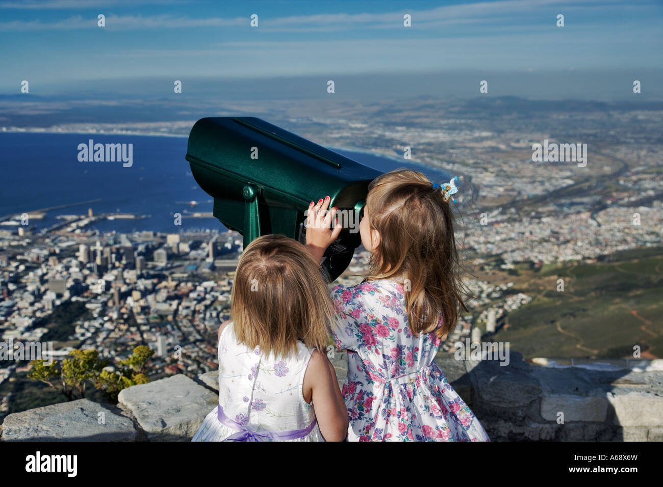 Zwei Kinder freuen sich über malerischen Blick durch ein Fernglas von Tabelle Berg Kapstadt Südafrika Modelle veröffentlicht Stockfoto