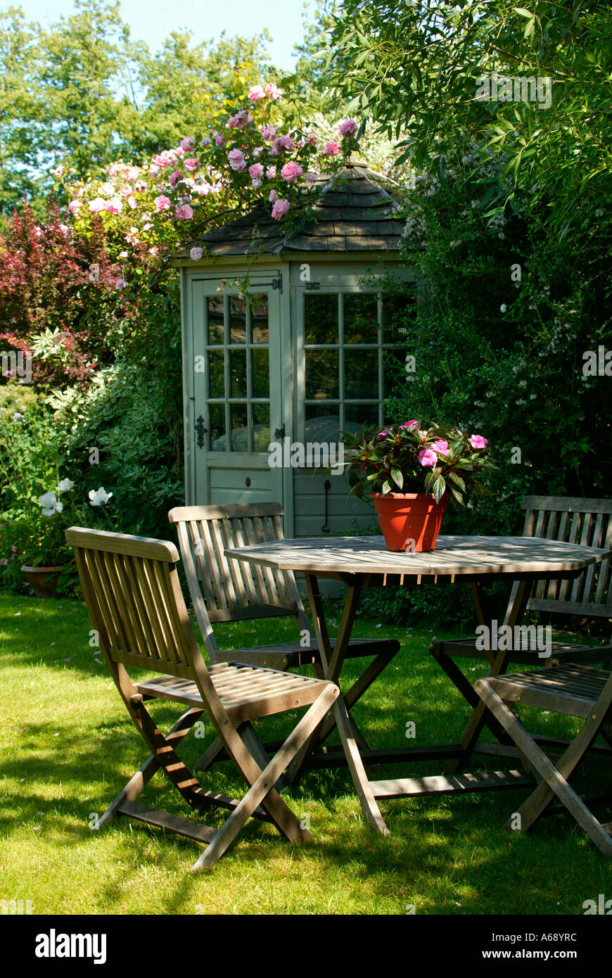 Laube, Tisch und Stühle im Sommer Englisch Garten Szene, England. Stockfoto