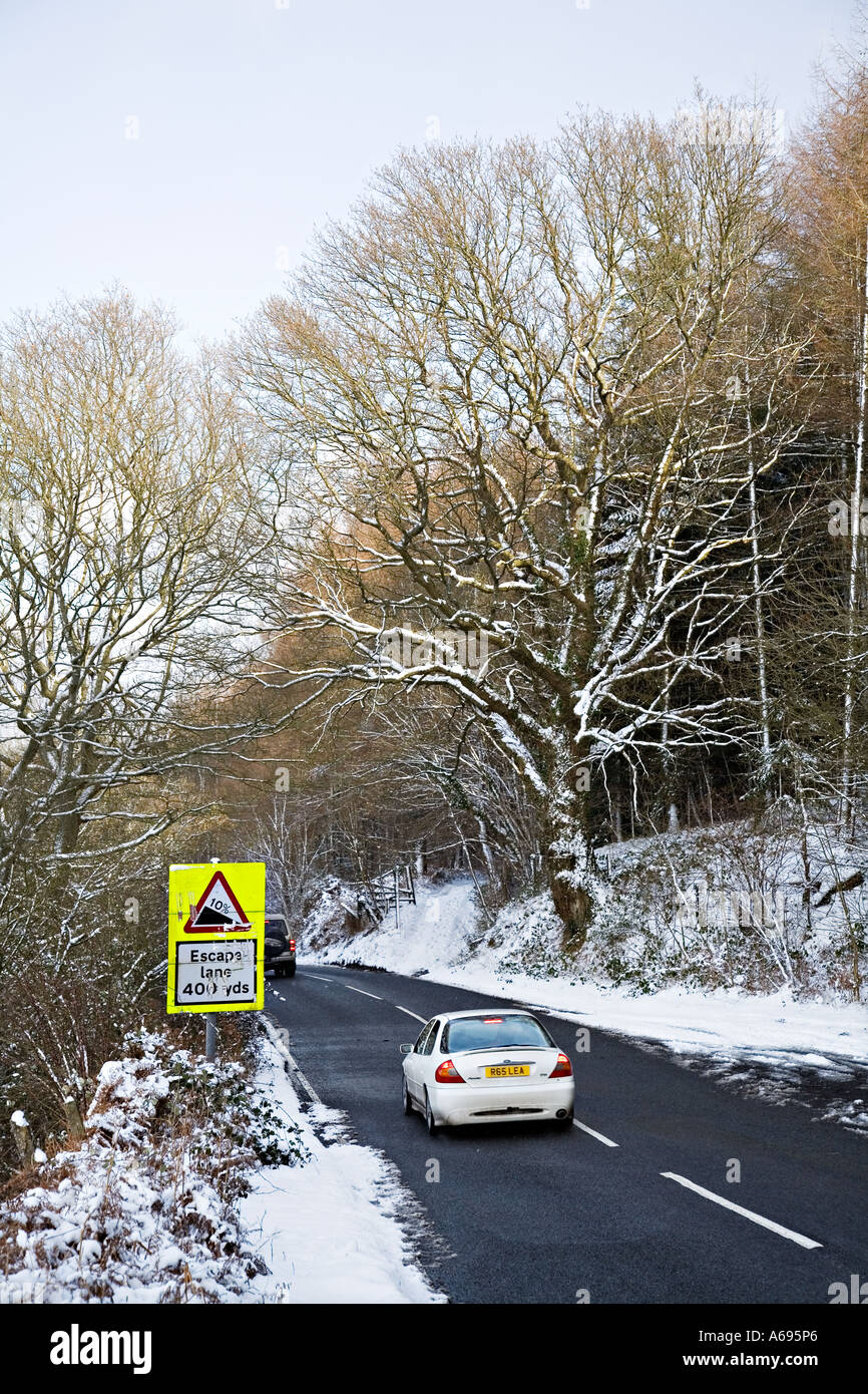Auto fahren bergab in winterlichen Bedingungen mit Escape Lane Warnschild Wales UK Stockfoto
