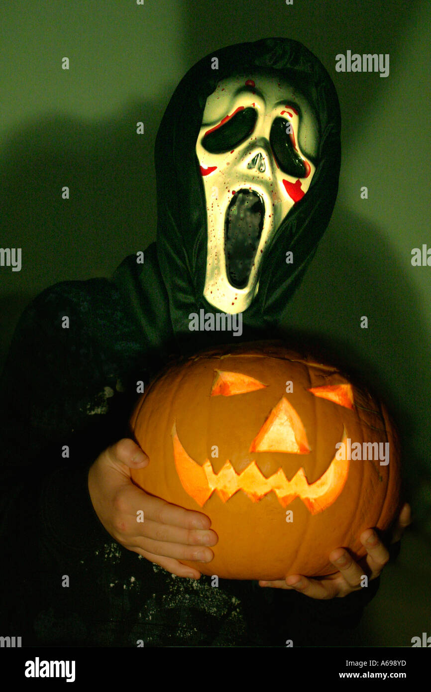 Junge in Halloweenmaske mit Kürbis Stockfoto