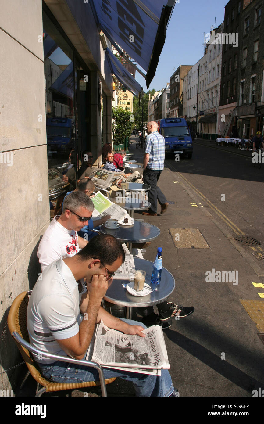 UK London Soho Frith Street Nero Coffee Shop Männer saßen draußen in der Sonne lesen Zeitung Stockfoto