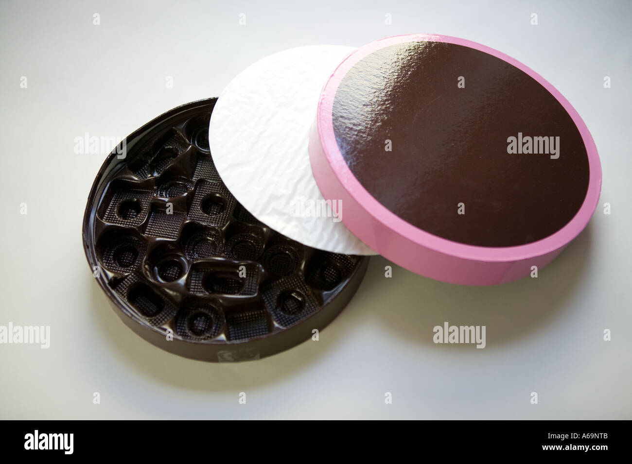 Studioaufnahme von einer leeren Kunststoff-Box von Schokolade auf eine glatte weiße Oberfläche Stockfoto