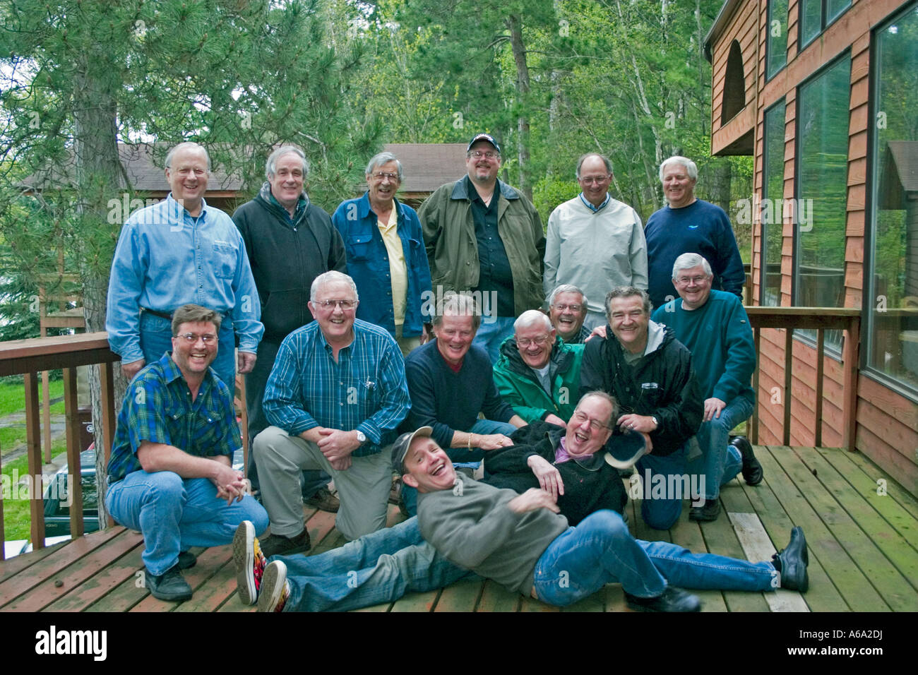 Fotograf in schwarzes Hemd, die versuchen, auf eine Reihe von erfahrenen Fischern ein Lächeln zaubern. Nisswa Minnesota USA Stockfoto