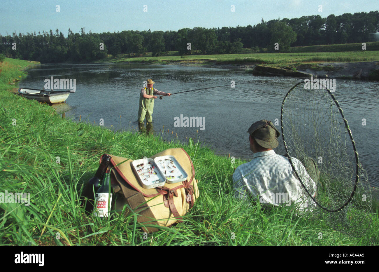 Lachs Angeln am Fluss Tweed mit Ghillie am Ufer Stockfoto