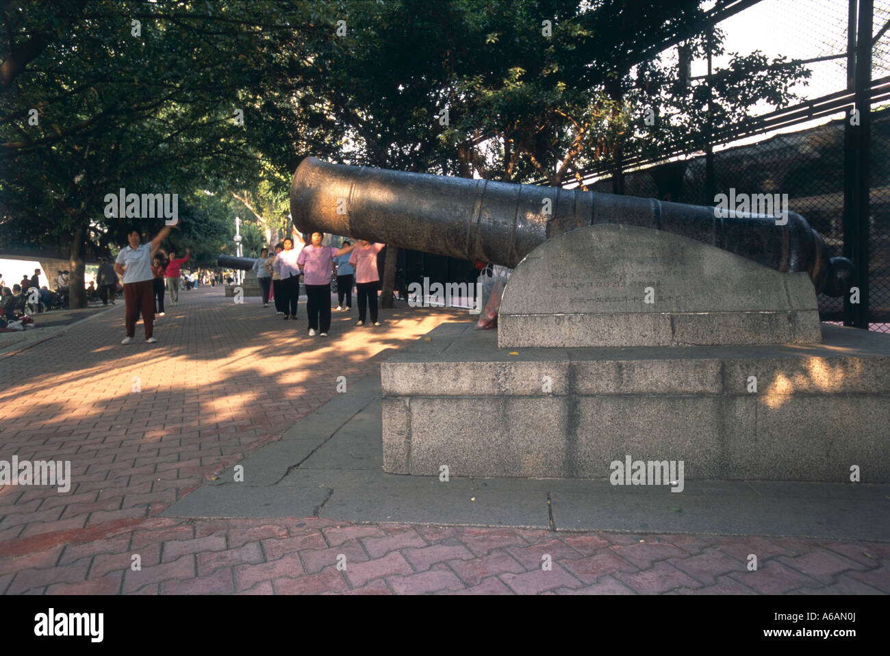Shamian Insel, Kanonen, Menschen, die Tai Chi im Hintergrund ausführen, Guangzhou, Guangdong, China verschwommen Bewegung Stockfoto