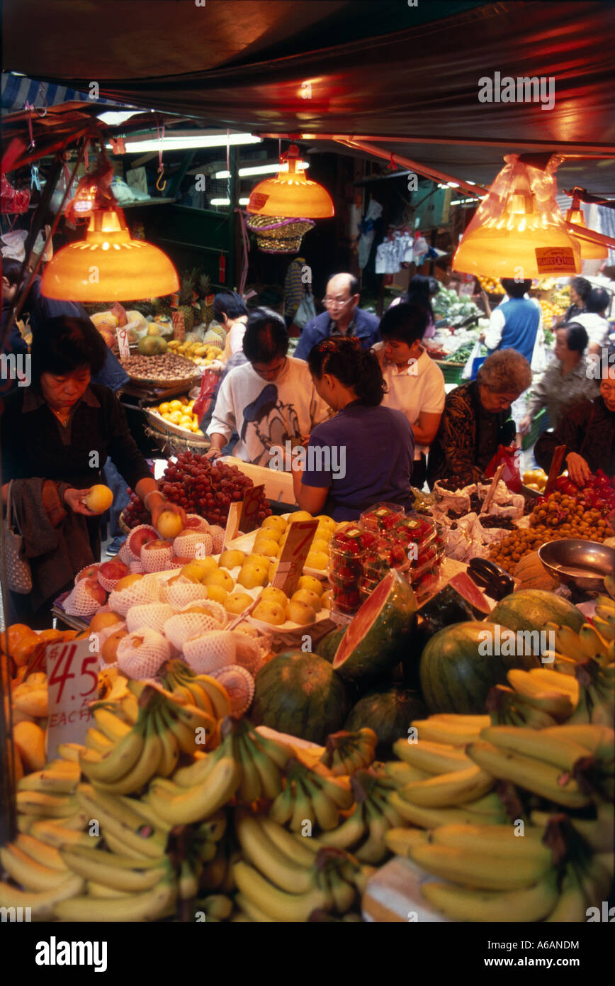 China, Hong Kong Island, Sheung Wan, Kunden für frisches Obst auf Frischwaren Stände in geschäftigen Markt hoch gestapelt Stockfoto
