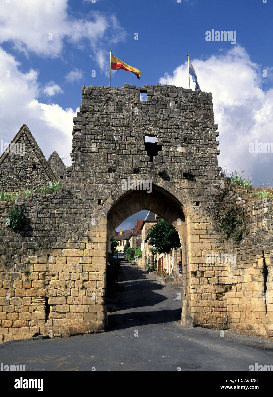 Porte Del Bos Gateway Arch Archiv Straßenszene enge mittelalterliche Straßenflagge auf der historischen Stadtmauer der Gemeinde Domme Dordogne Nouvelle Aquitaine Frankreich EU Stockfoto