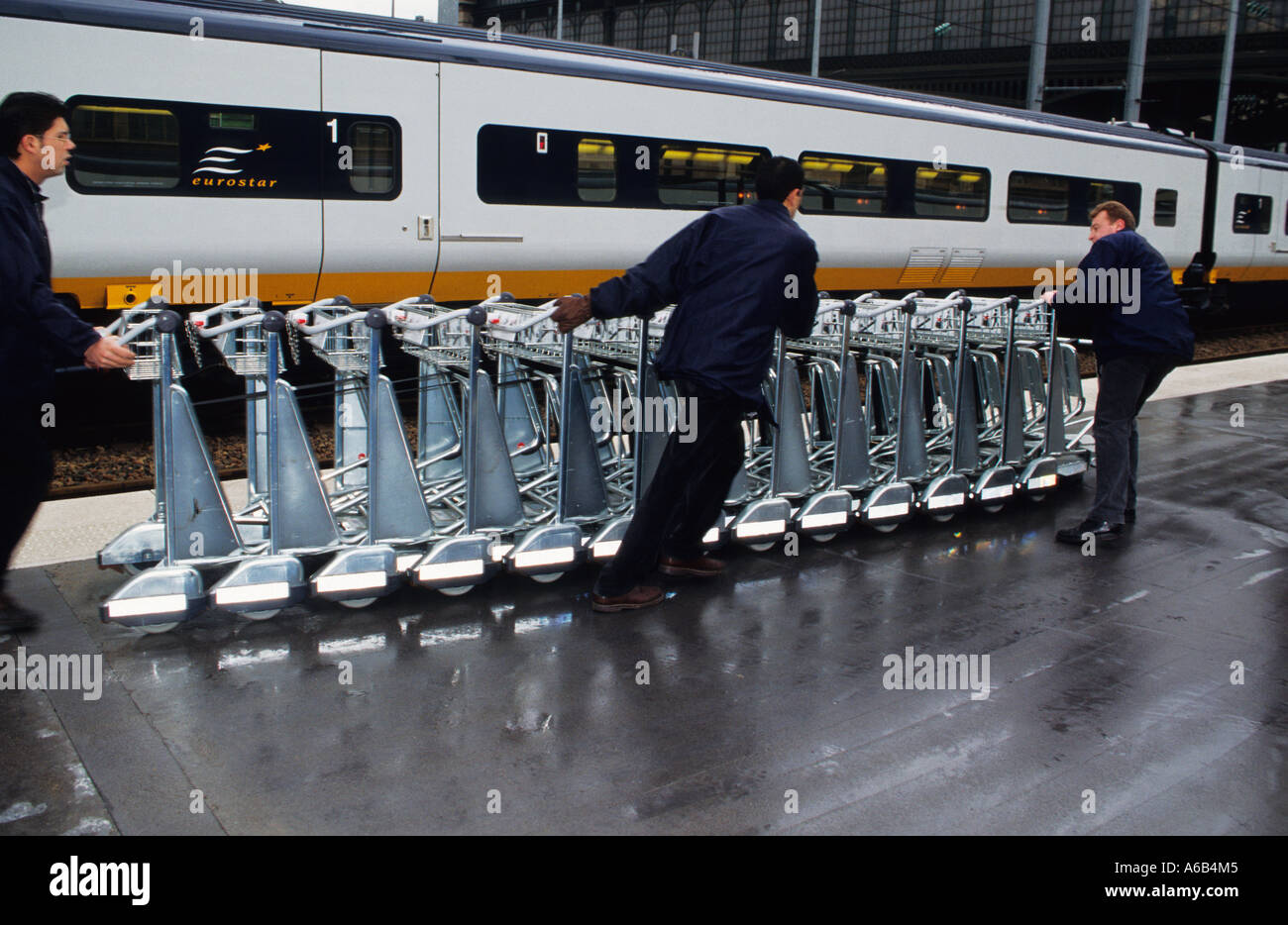 Bahnsteig Gare du Nord Paris. Bedienstete stapeln leere Gepäckwagen