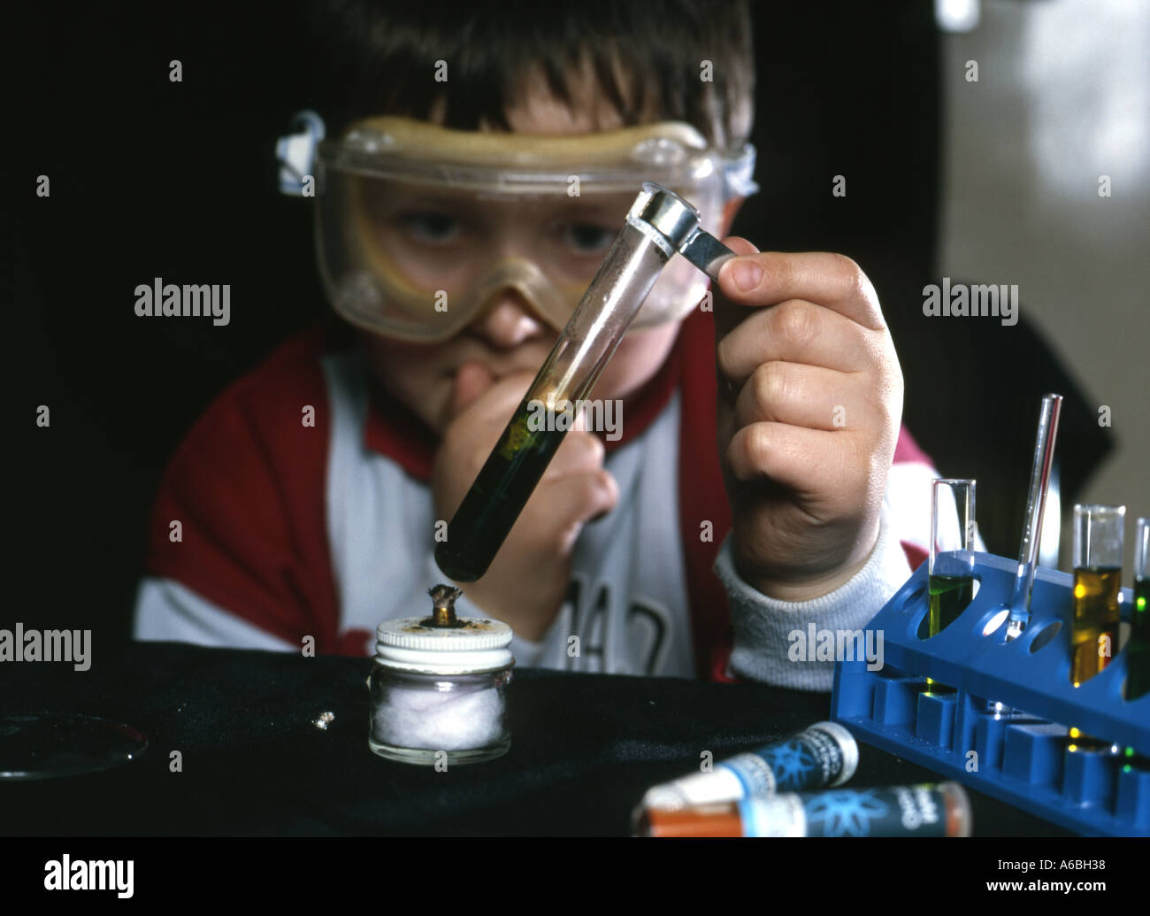 Junge mit Chemie setzen Reagenzglas und goggle Augenschutz Stockfoto