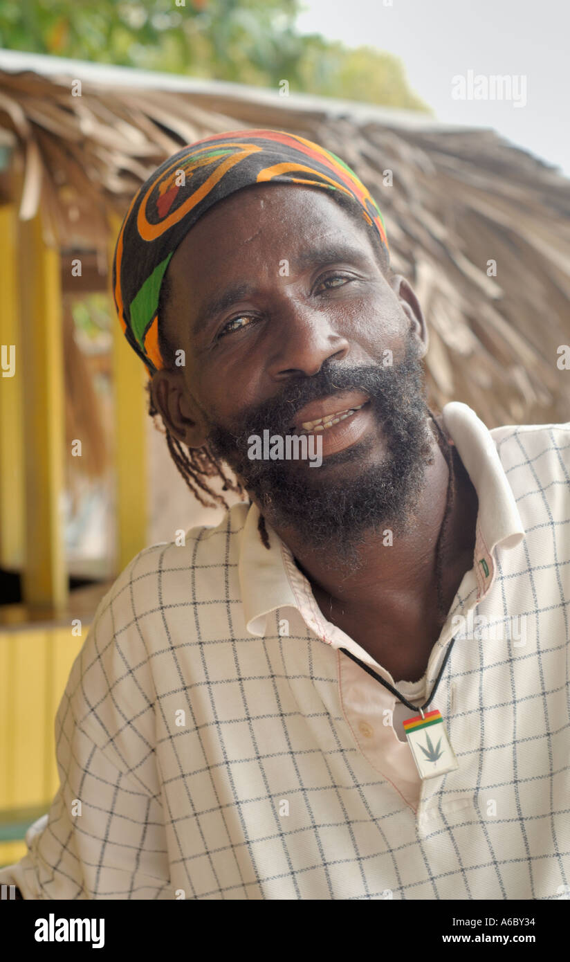 Ein vertikaler Farbbild ein Rastafari Mann trägt eine Art Poloshirt mit seinen Haaren in einem Banadana und einem Ganja-Anhänger um seinen Stockfoto