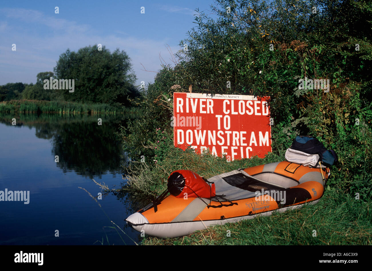 Verschluss / versteckte Gefahrenzeichen: Fluss geschlossen für den nachgelagerten Verkehr mit Kajak auf grasbewachsenen Ufer, River Thames, England Stockfoto