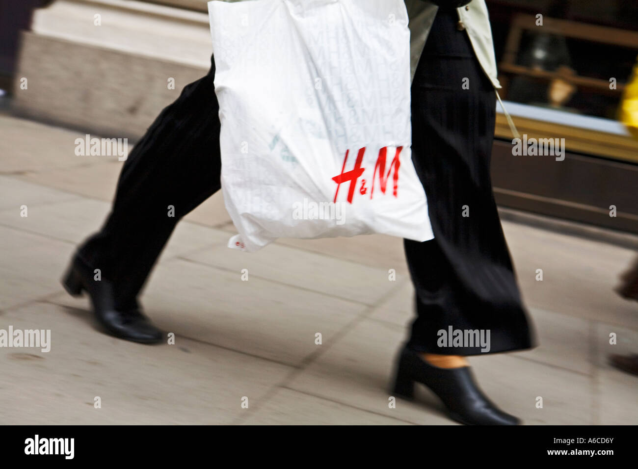 Käufer trägt H & M Shopping Bag, wie geht sie auf Oxford Straße Stockfoto