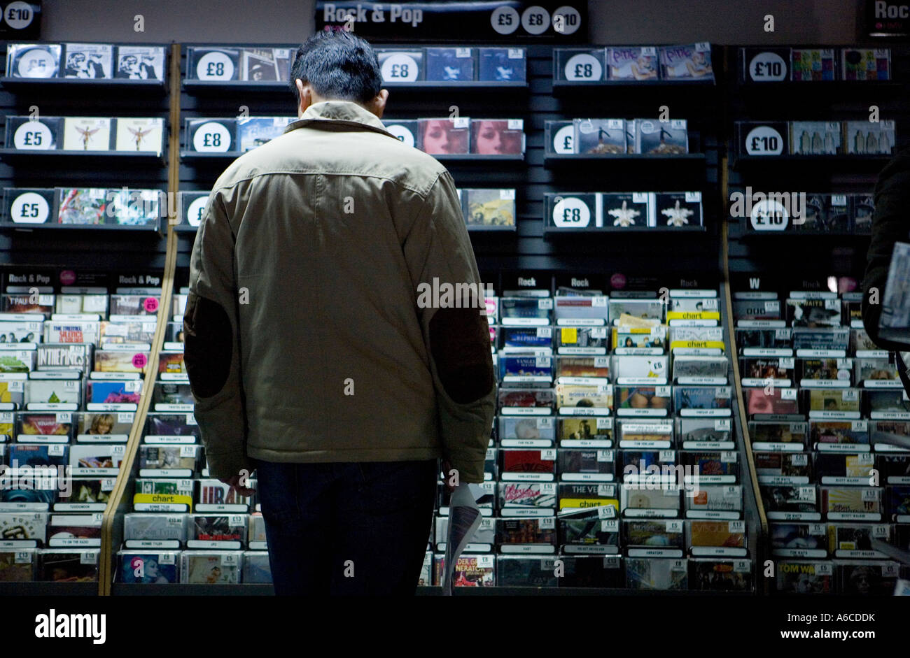 Man fallen schaut auf CDs im HMV am Piccadilly Circus CD-Verkäufe Rack wie Online-Musik-erhöhen Downloads Stockfoto
