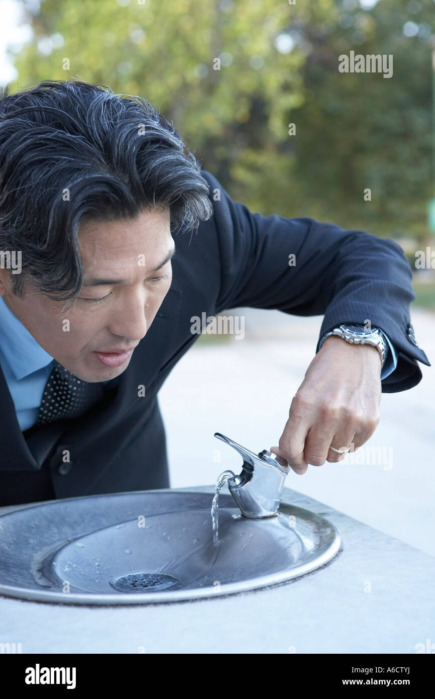 Geschäftsmann, trinken am Brunnen Stockfoto