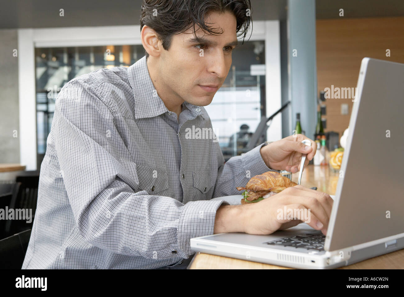 Mann mit Laptop und Essen Stockfoto