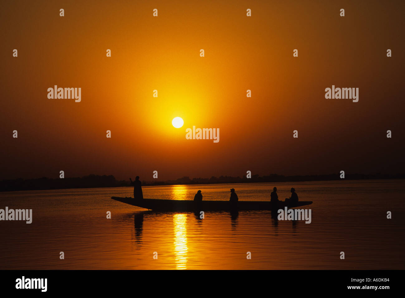 Ein traditionelles gegraben, Kanu oder Piroge, bei Sonnenuntergang auf dem Fluss Niger, Mali silhouetted, West Afrika Stockfoto