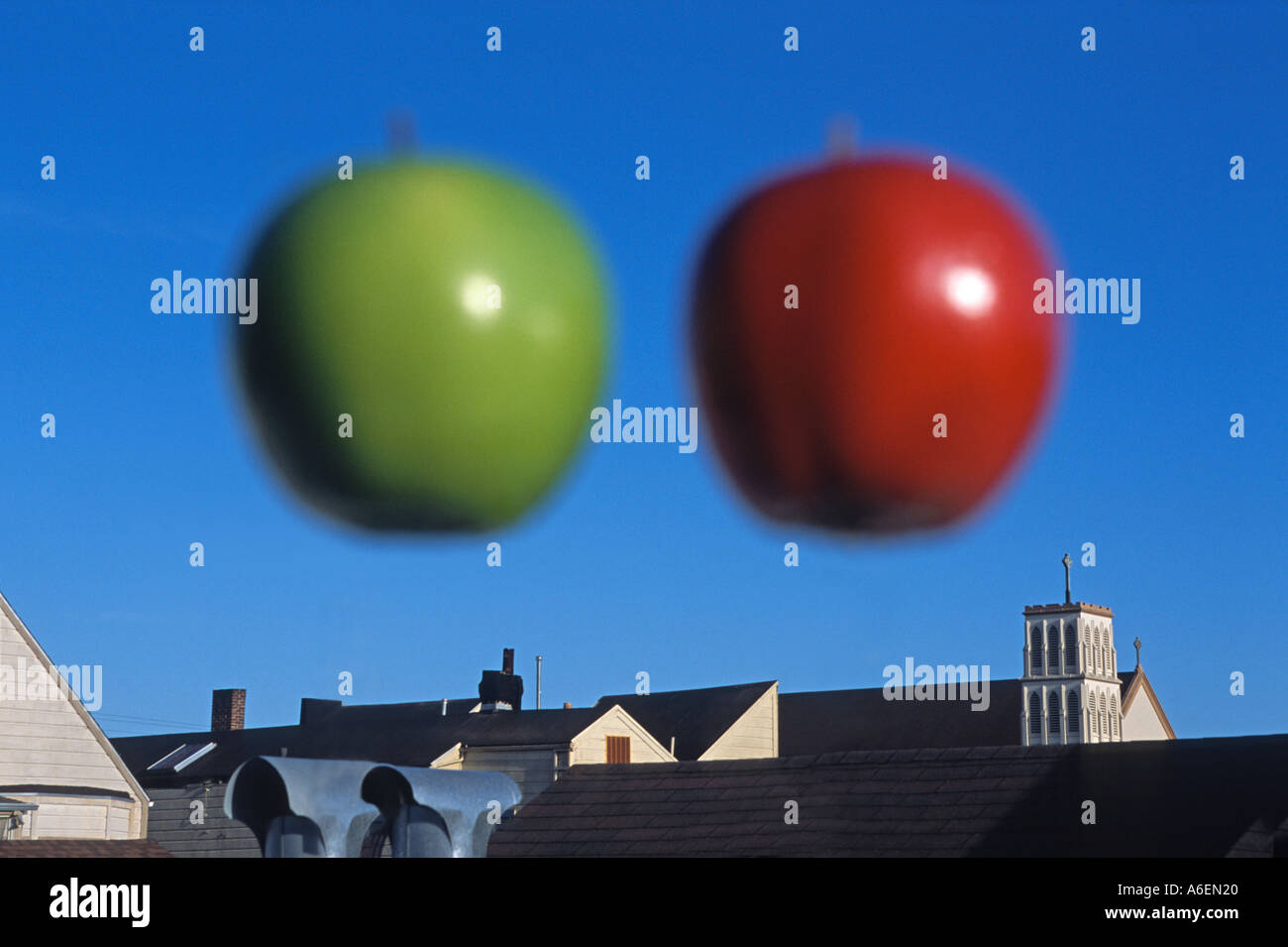 "Unscharfe Äpfel, rot und grün, schwebt über den Dächern" Stockfoto