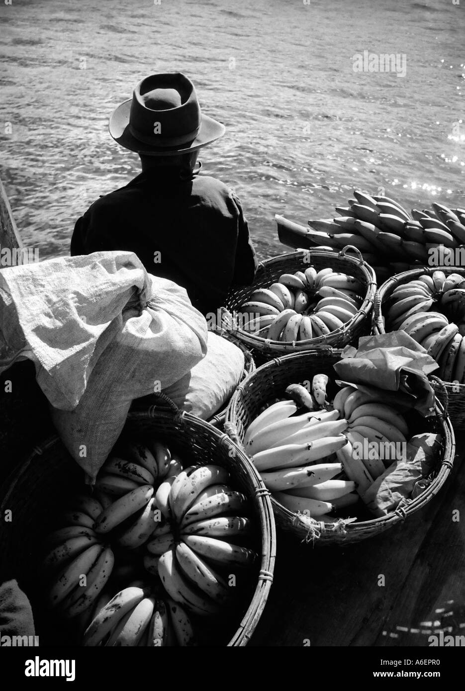 Mann mit Körben von Bananen, die darauf warten, mit dem Boot auf See Toba in Sumatra Indonesien transportiert werden Stockfoto