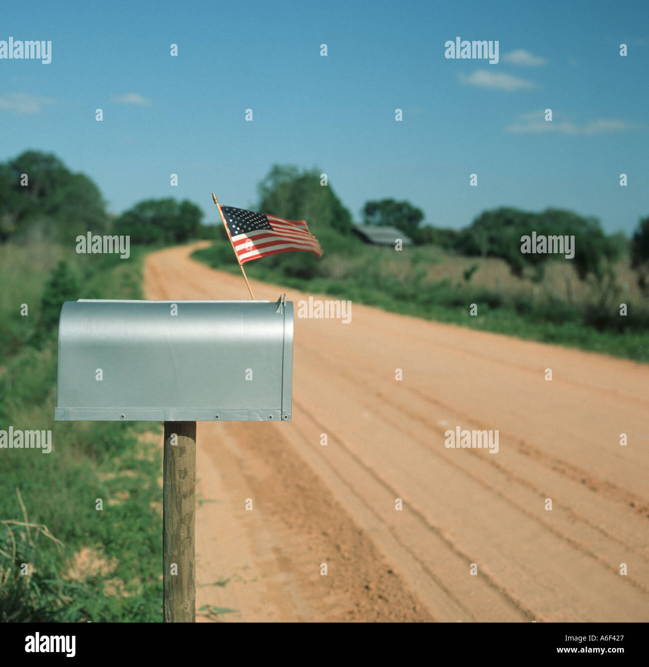 Postfach mit kleinen USA-Flagge auf Landstraße Ton Stockfoto