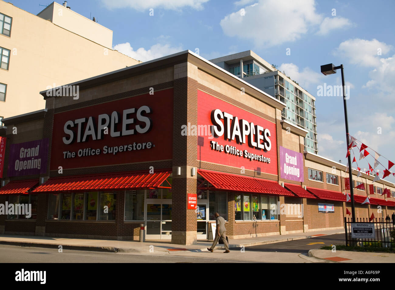 ILLINOIS Chicago außen von Staples Büro Zubehör Shop Mann hinunter Bürgersteig Eröffnung Zeichen Stockfoto