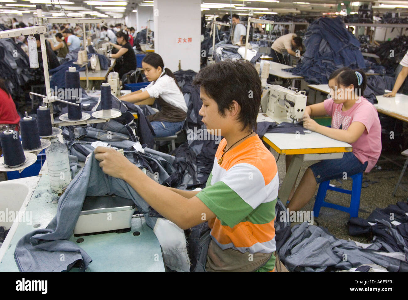 SHENZHEN GUANGDONG Provinz CHINA Arbeiter Nähen Mango Jeans in ...