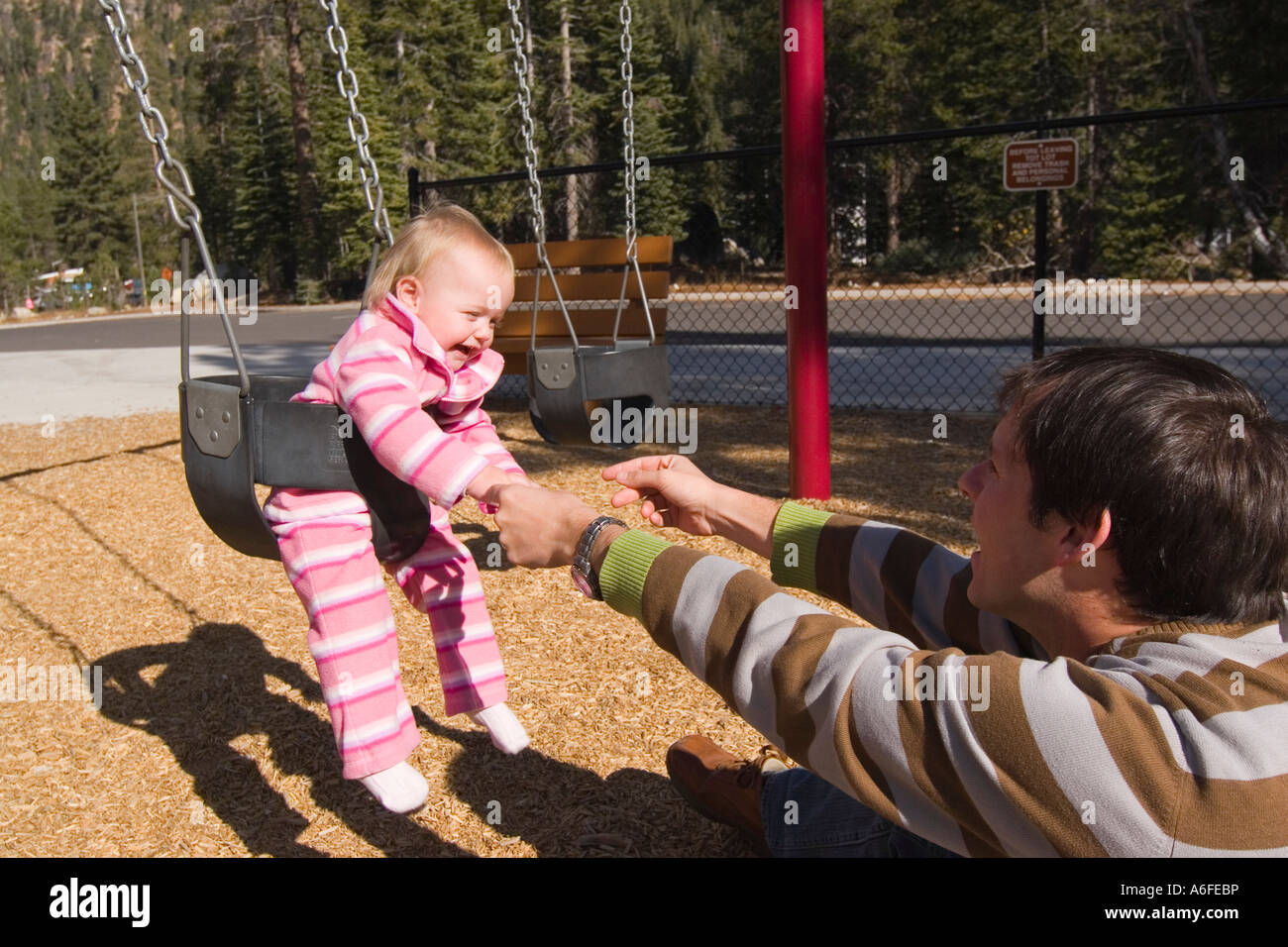Ein Vater und Kind auf einem Spielplatz in der Nähe von Squaw Valley Kalifornien schwingen Stockfoto