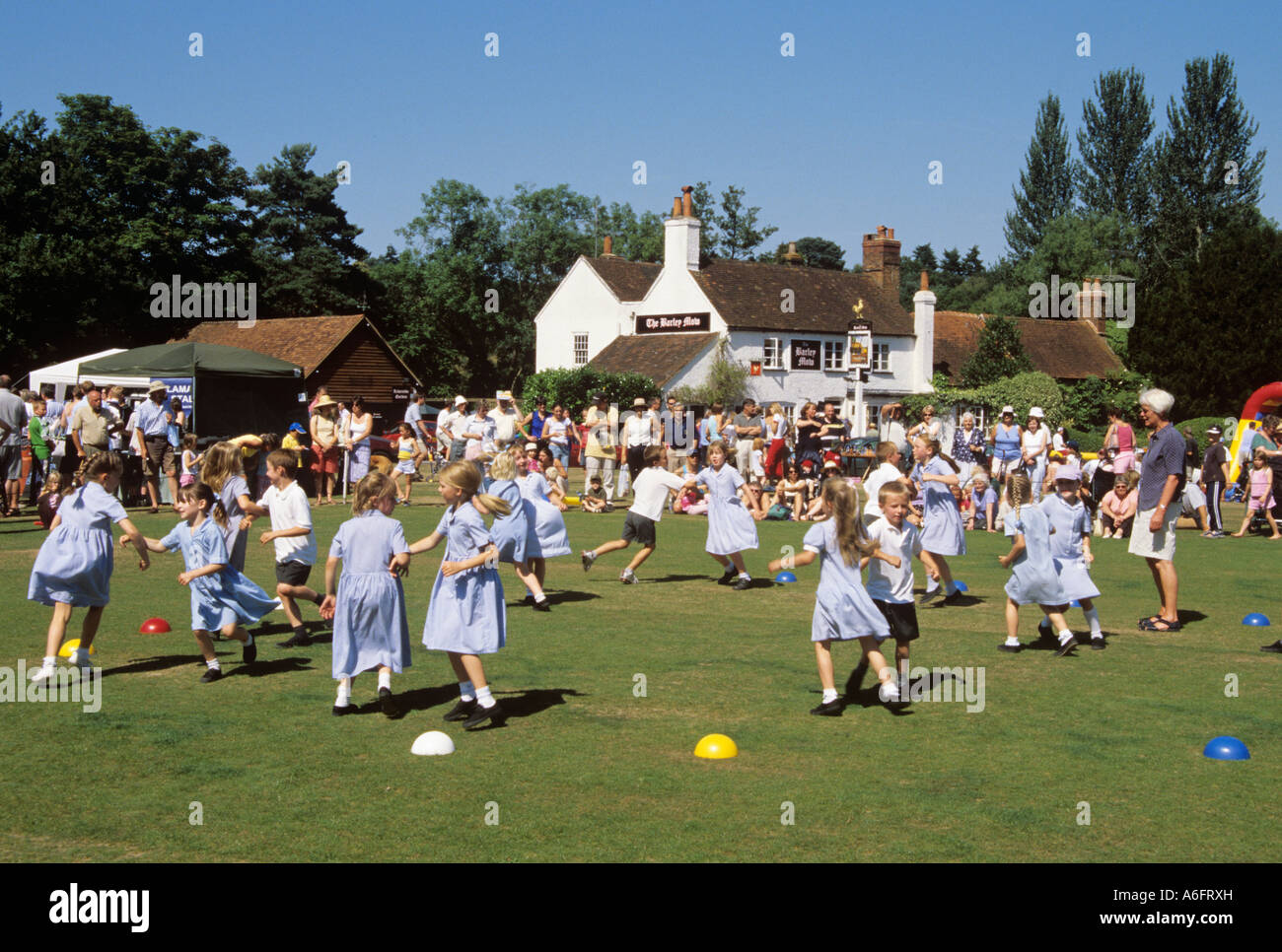TILFORD Sommer Dorffest mit Kinder-Country Dance auf einem Dorfplatz. Tilford Surrey England UK Großbritannien Stockfoto