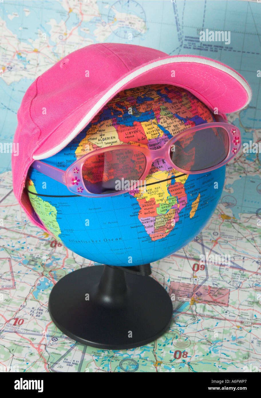 Globus mit Sonnenbrille und Kappe vor einer Luftfahrtkarte, Symbol für die  Welt-Tour und Reisen Stockfotografie - Alamy