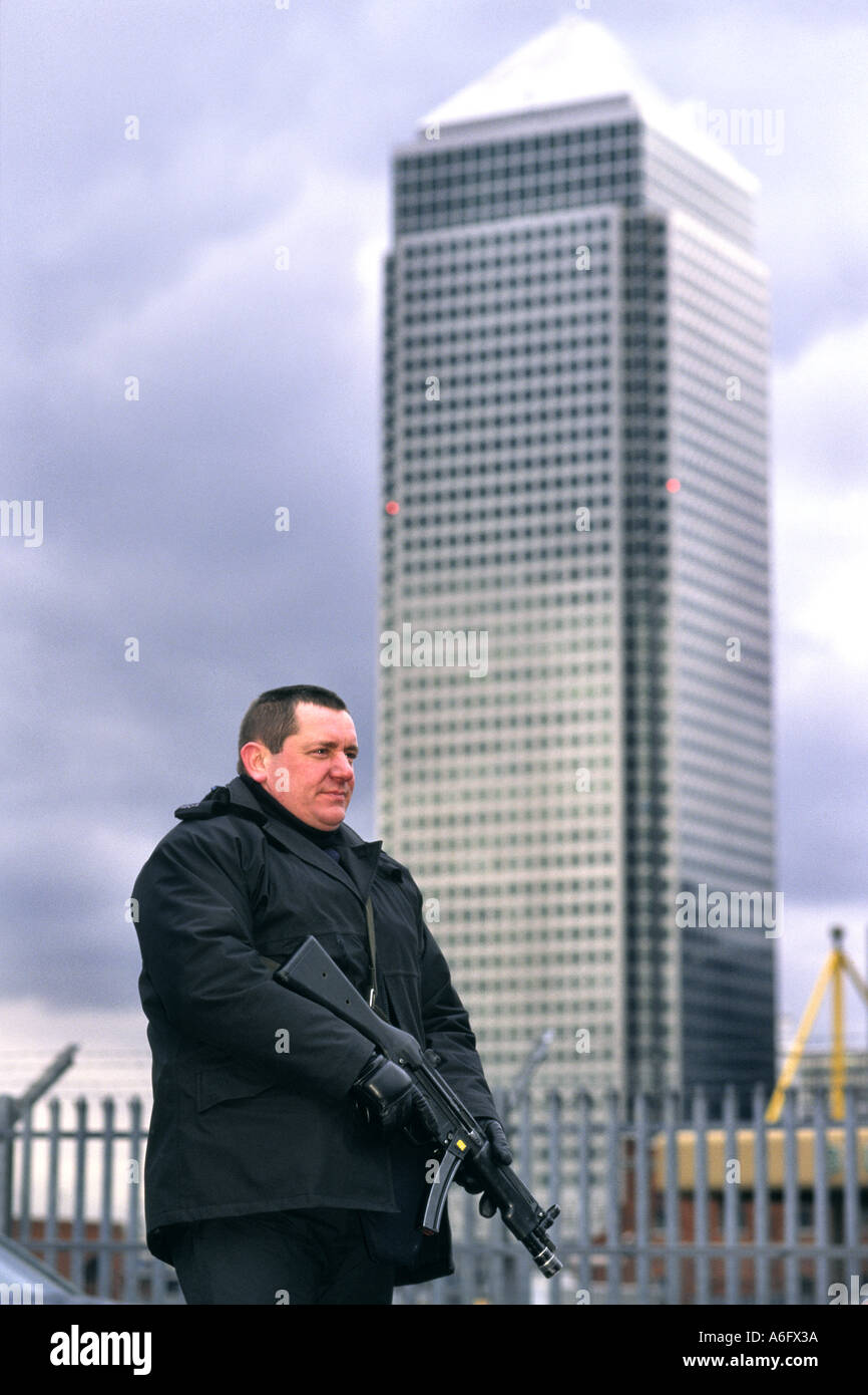 Ein bewaffneter Polizist mit seiner automatischen Waffe im Anschlag steht Wache von Canary Wharf. Stockfoto