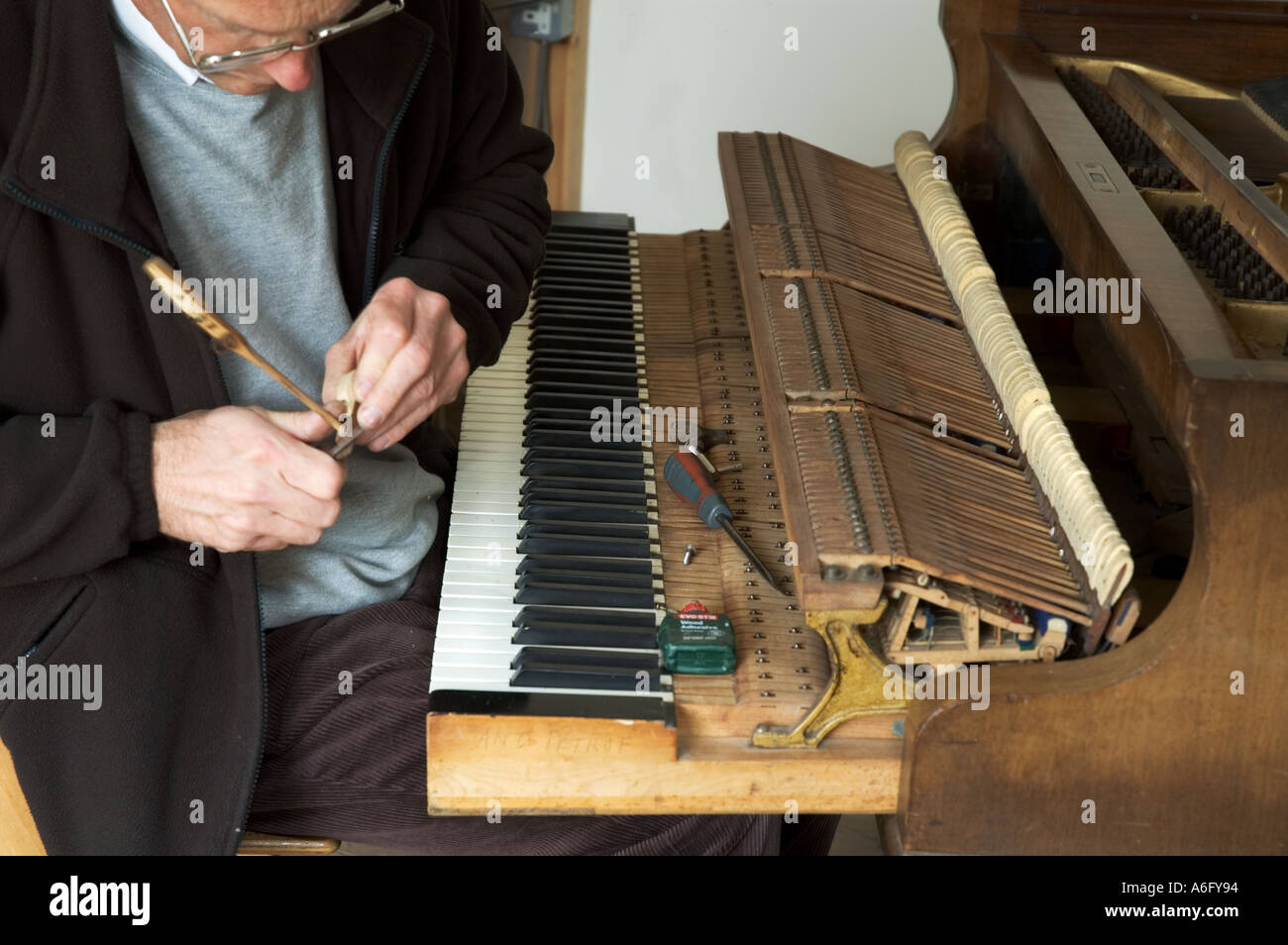 Ein Klavier Retorer arbeitet auf ein Baby Grand Piano. Stockfoto