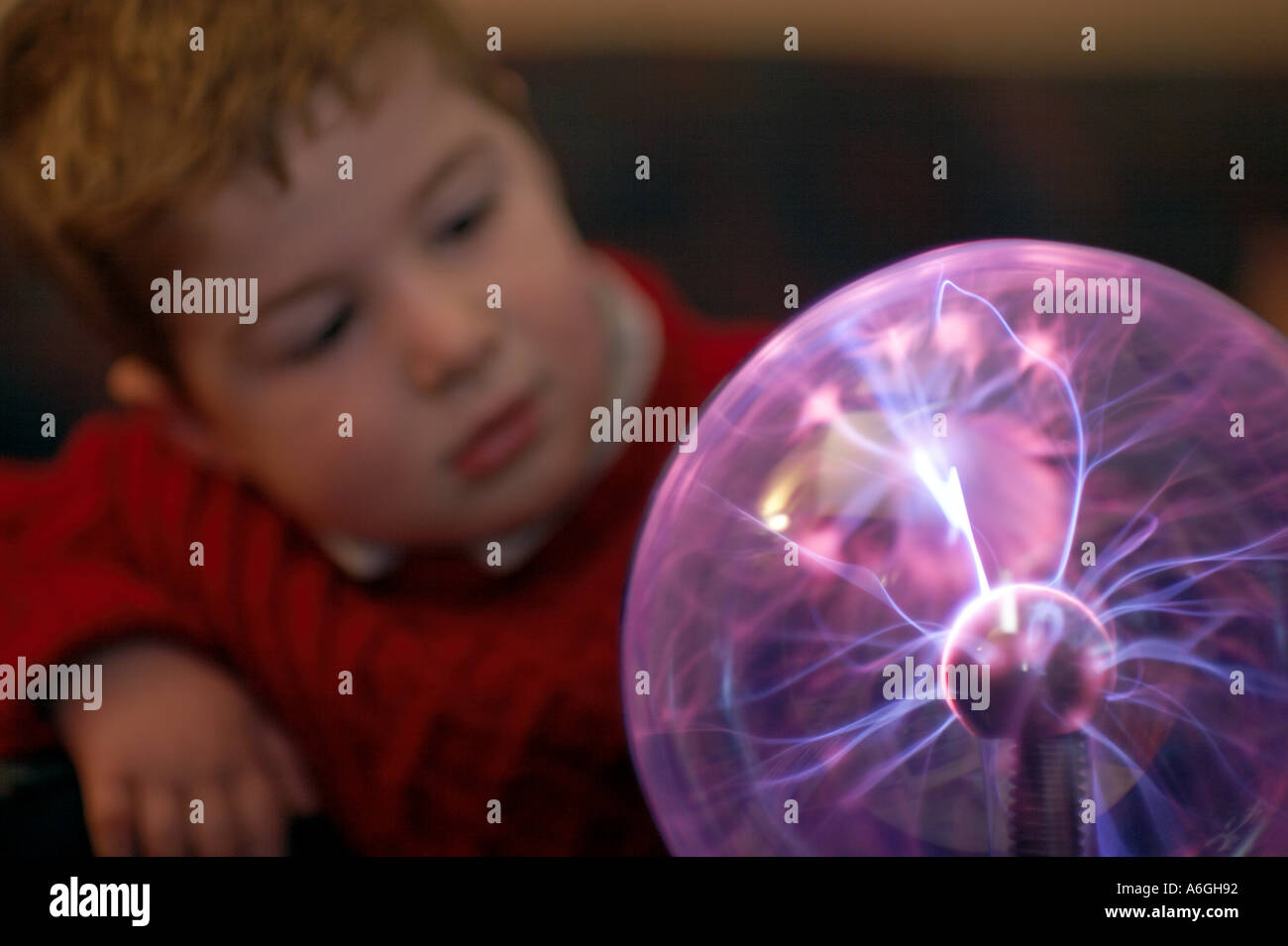 Neugierige neugierige junge Blick auf Plasma Kugel Kugel wissenschaftlichen Spielzeug Stockfoto