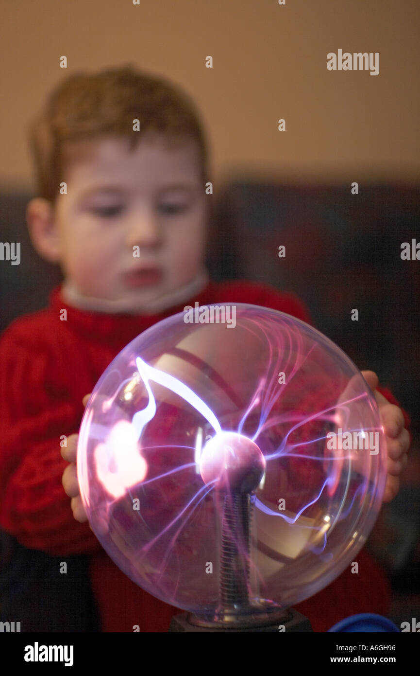 Neugierige neugierige junge betrachten und berühren einen Plasma Kugel Ball wissenschaftlichen Spielzeug Stockfoto