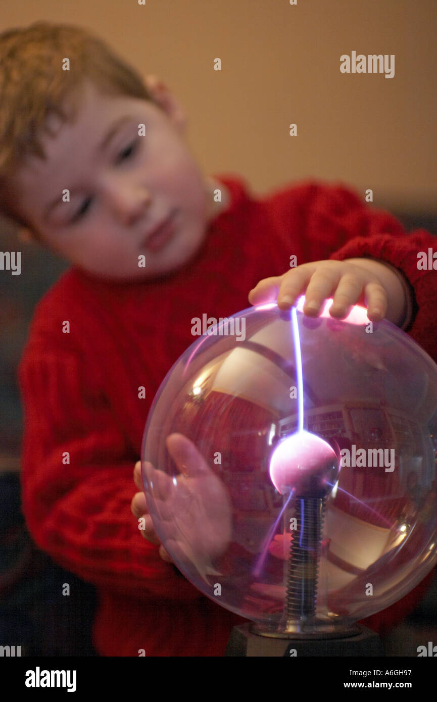 Neugierige neugierige junge betrachten und berühren einen Plasma Kugel Ball wissenschaftlichen Spielzeug Stockfoto