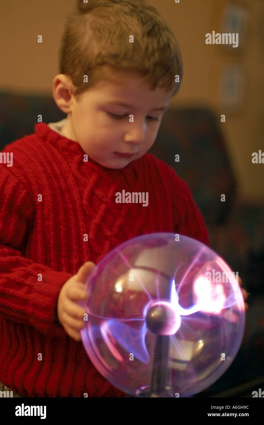 Neugierige neugierige junge betrachten und berühren einen Plasma Kugel Ball wissenschaftlichen Spielzeug Stockfoto