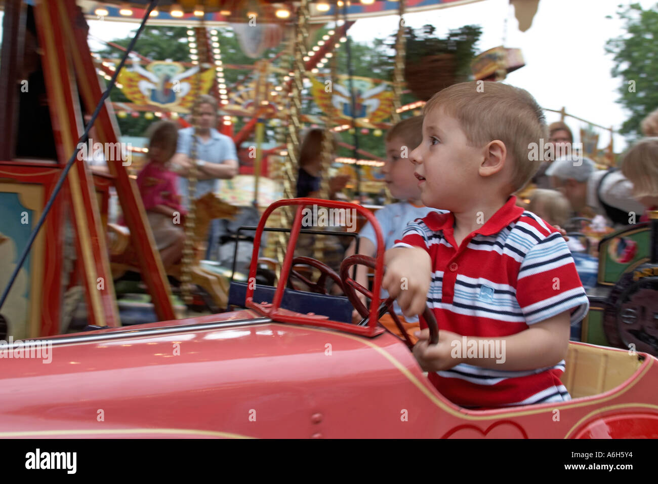 Kleiner junge Kind auf ein Modell Auto Messegelände fahren Carter s Steam Fair Jahrmarkt im Priorat Park London N8 Stockfoto