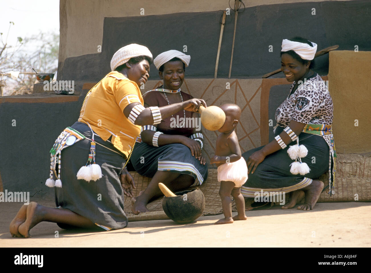 Eine Mutter füttert ihr Baby von einer traditionellen Kalebasse in einem afrikanischen Dorf in der Nähe der Stadt Tzaneen in Südafrika. Stockfoto