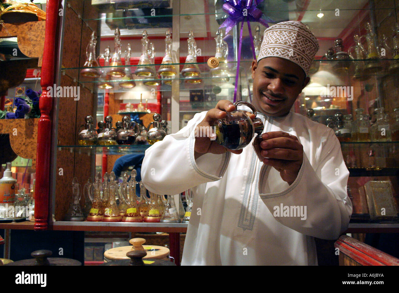 Nizwa, Oman, ein Perfumier Gießen Parfüm in eine Glasflasche in einem berühmten shop Stockfoto