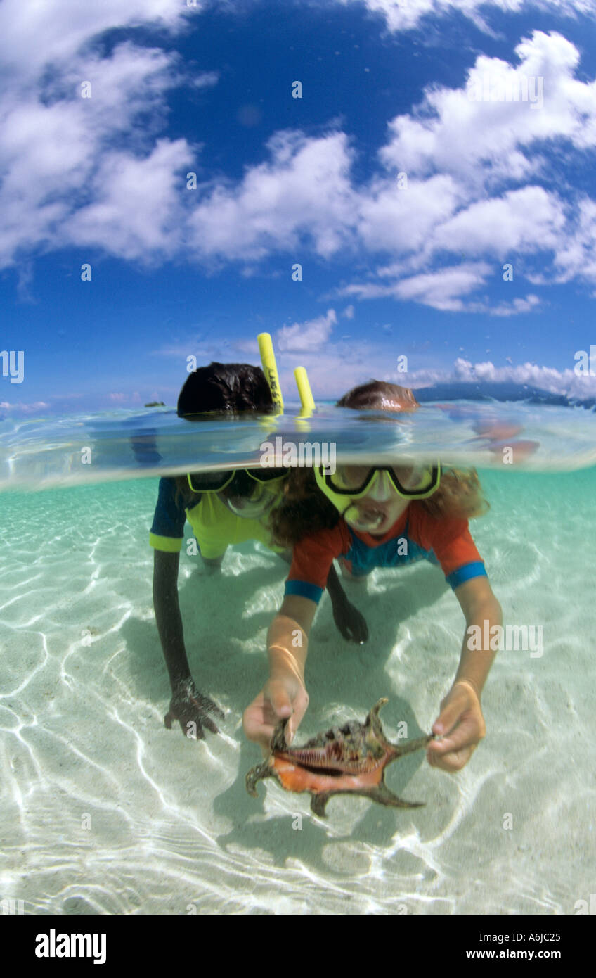 Unter Wasser geteilte Ansicht von zwei Mädchen, Schnorcheln über weißen Sand im Pazifik Stockfoto