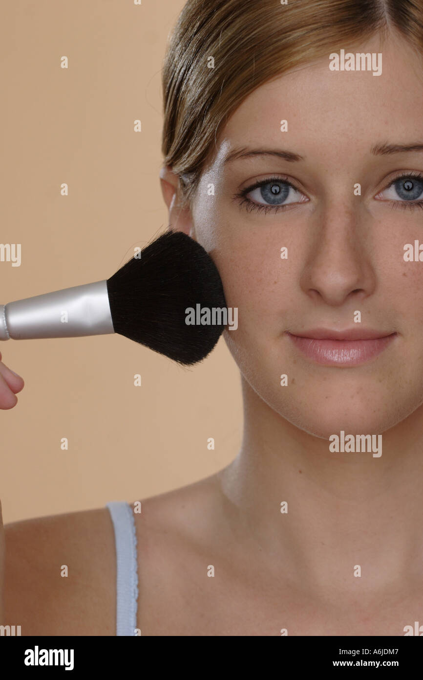 junge Frau, die ihr Gesicht Pudern Stockfoto