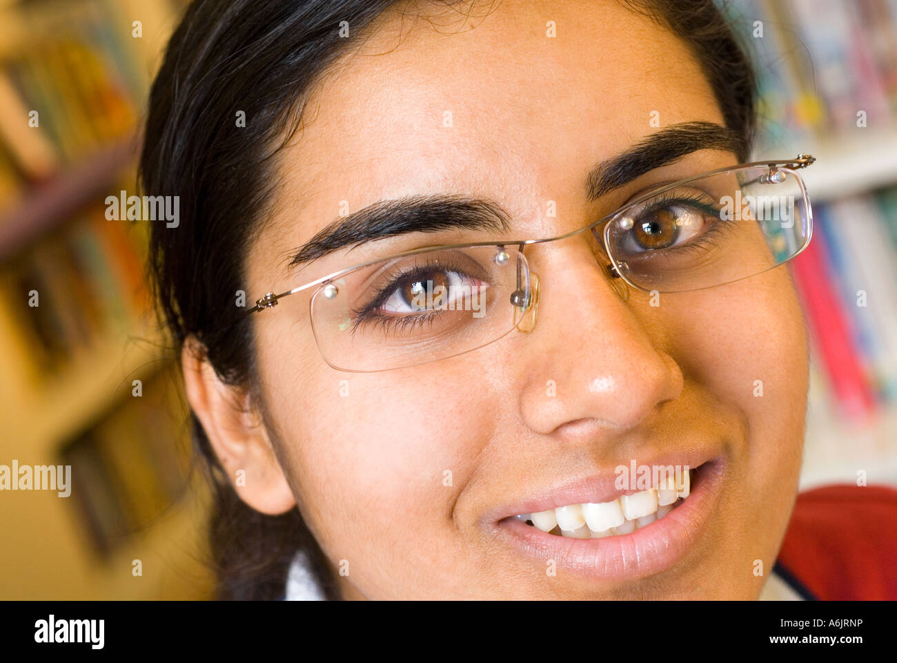 Asiatische Jugendmädchen student attraktive einheitliche schließen Lächeln zuversichtlich Brille in der Schule Bibliothek Stockfoto