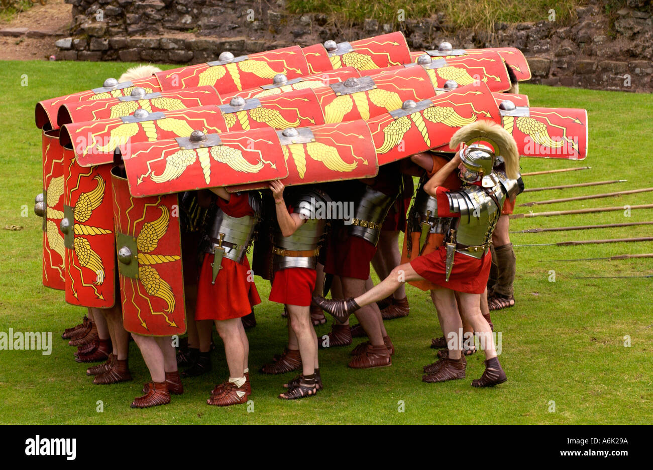 Ermine Street Guard demonstrieren die Schildkröte defensive Manöver im Display der Kampffähigkeiten im römischen Amphitheater Caerleon UK Stockfoto