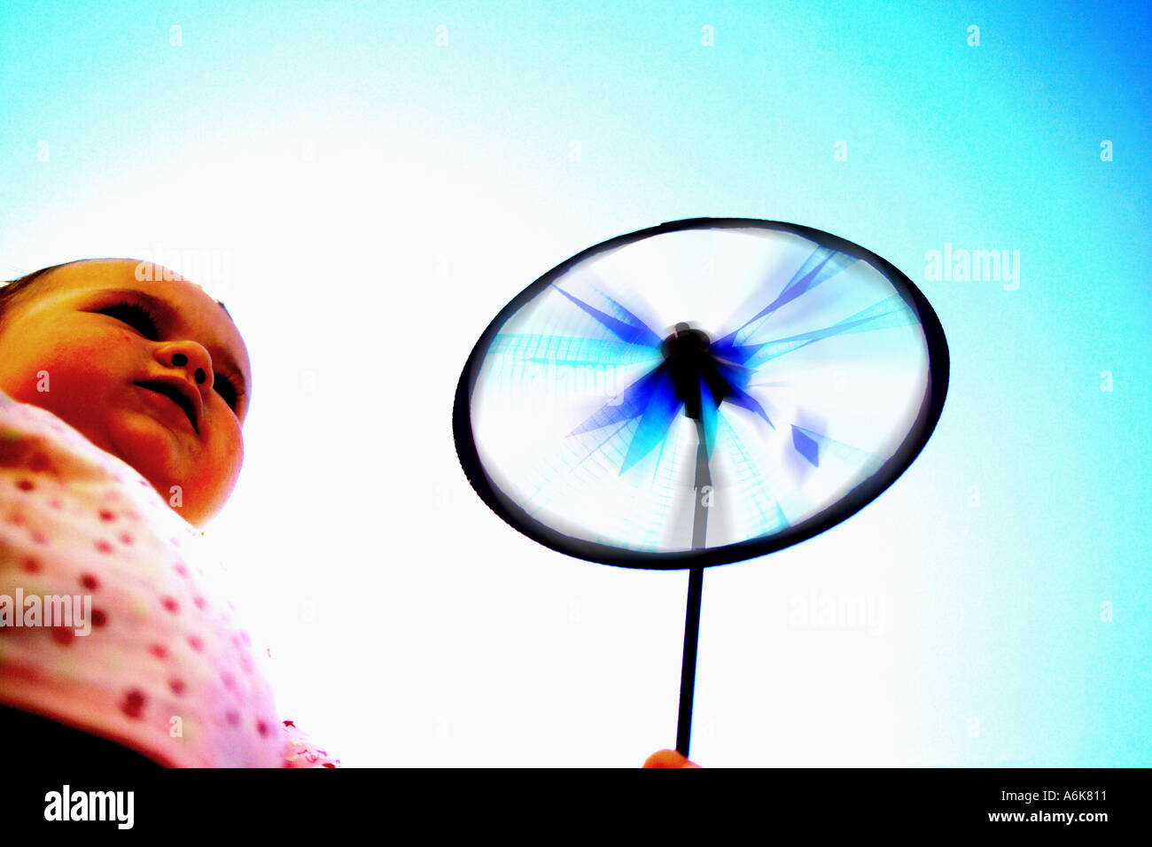 wenig baby hält einen Windwheel in den Himmel Stockfoto