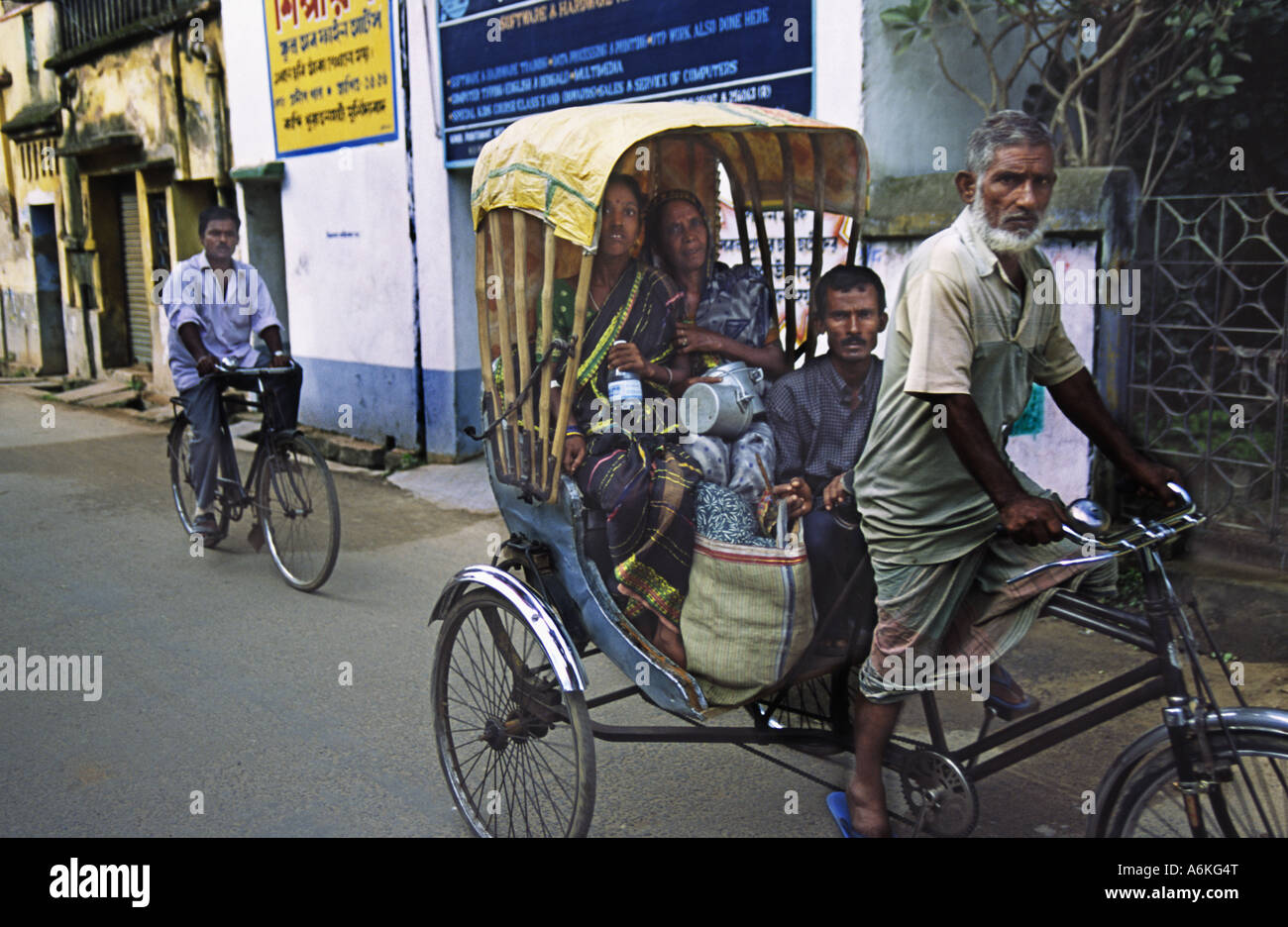 Passagiere, die auf einer Fahrrad-Rikscha in West Bengalen, Indien transportiert werden Stockfoto